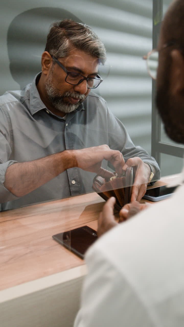 Man paying with cash at a counter