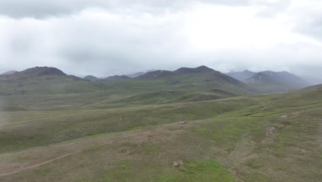 Aufsteigende-Drohnenaufnahmen-Von-Grünen-Wiesen-Und-Grünem-Land-Zwischen-Dem-Pakistanischen-Berg-Desai-Skardu-Bei-Regen-Und-Tropfen-Auf-Der-Kameralinse