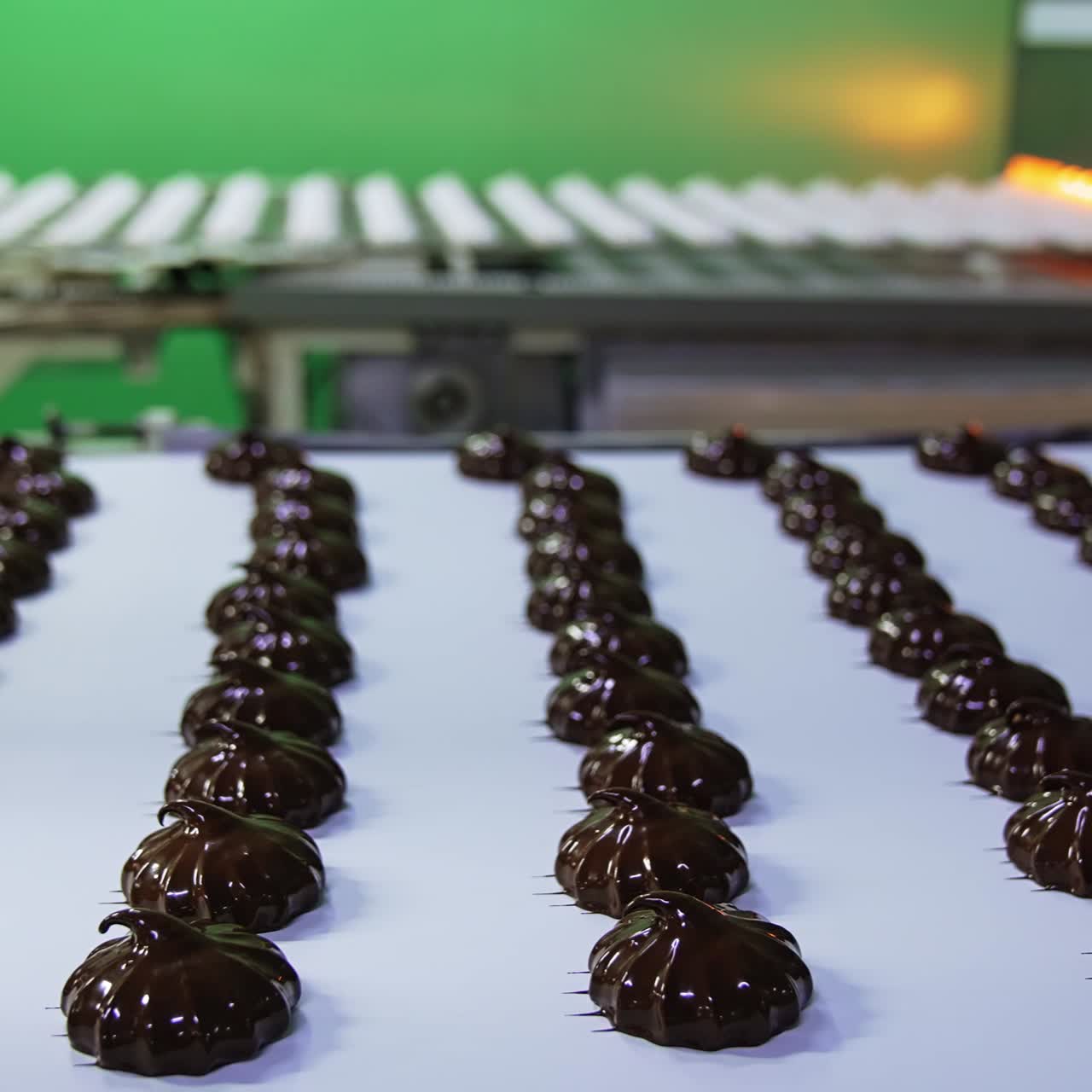 Chocolate covered marshmallows on a conveyor belt