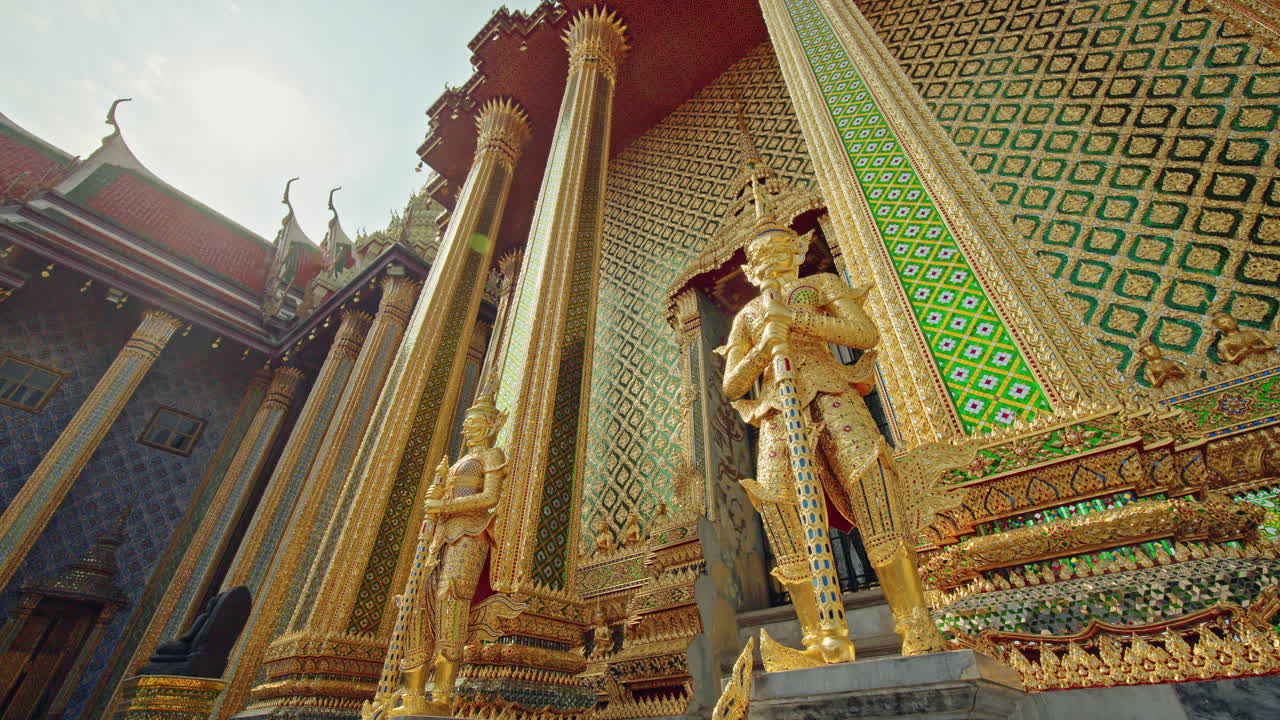Golden guardian statues and ornate temple facade at Wat Phra Kaew in Bangkok, traditional Thai architecture in Thailand