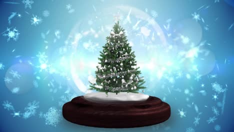 animation of christmas tree in snow globe, with falling snowflakes and glowing lights on blue