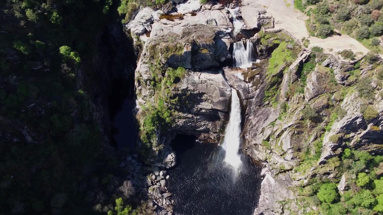 Veduta aerea con drone 4K della maestosa doppia cascata Pozo de los Humos a Salamanca, Spagna. Potente flusso d'acqua ad alto volume che si getta nel canyon roccioso circondato da una lussureggiante vegetazione verde.