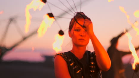 bailarines de fuego contra el atardecer. una joven posa con su aro de fuego contra la puesta de sol durante su actuación de baile