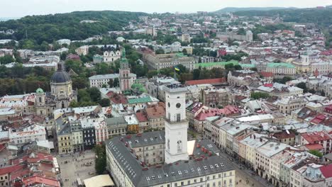 Rynok-Square-in-Lviv-Ukraine-with-the-Ukrainian-flag-flying-on-top-of-a-tower-in-city-hall-surrounded-by-old-European-buildings