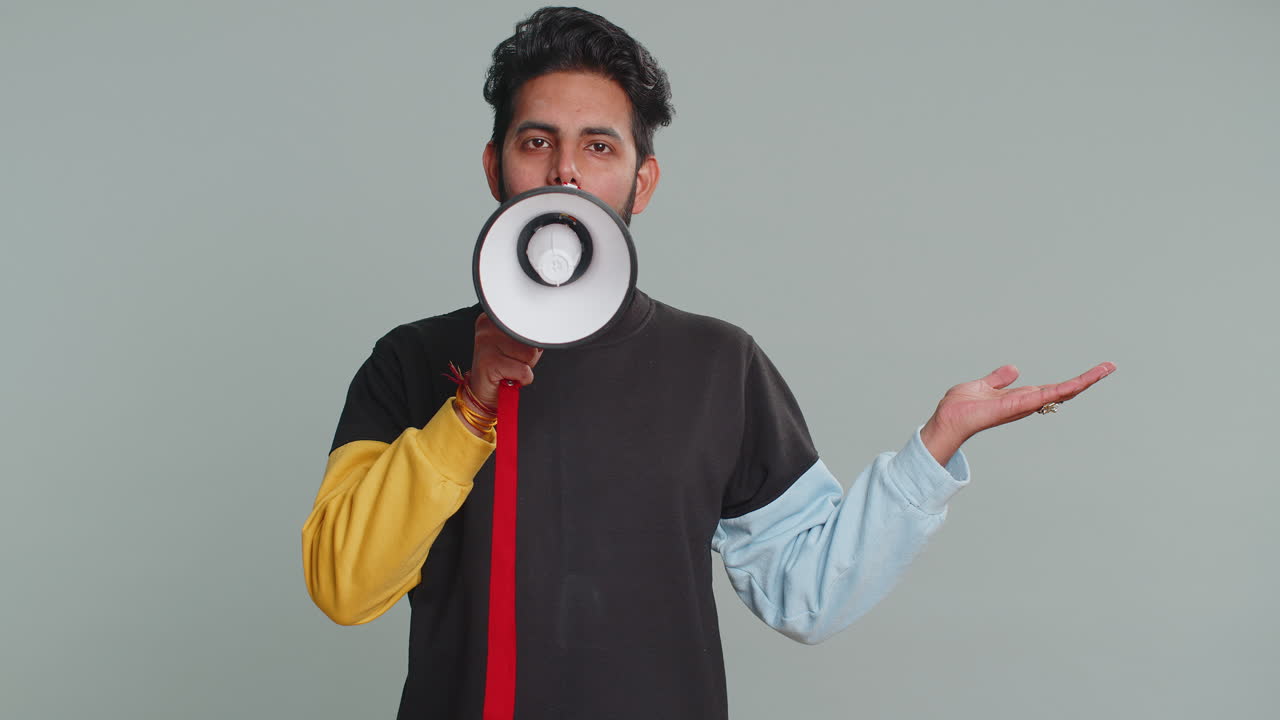 Man talking with megaphone proclaiming news loudly announcing advertisement pointing empty place