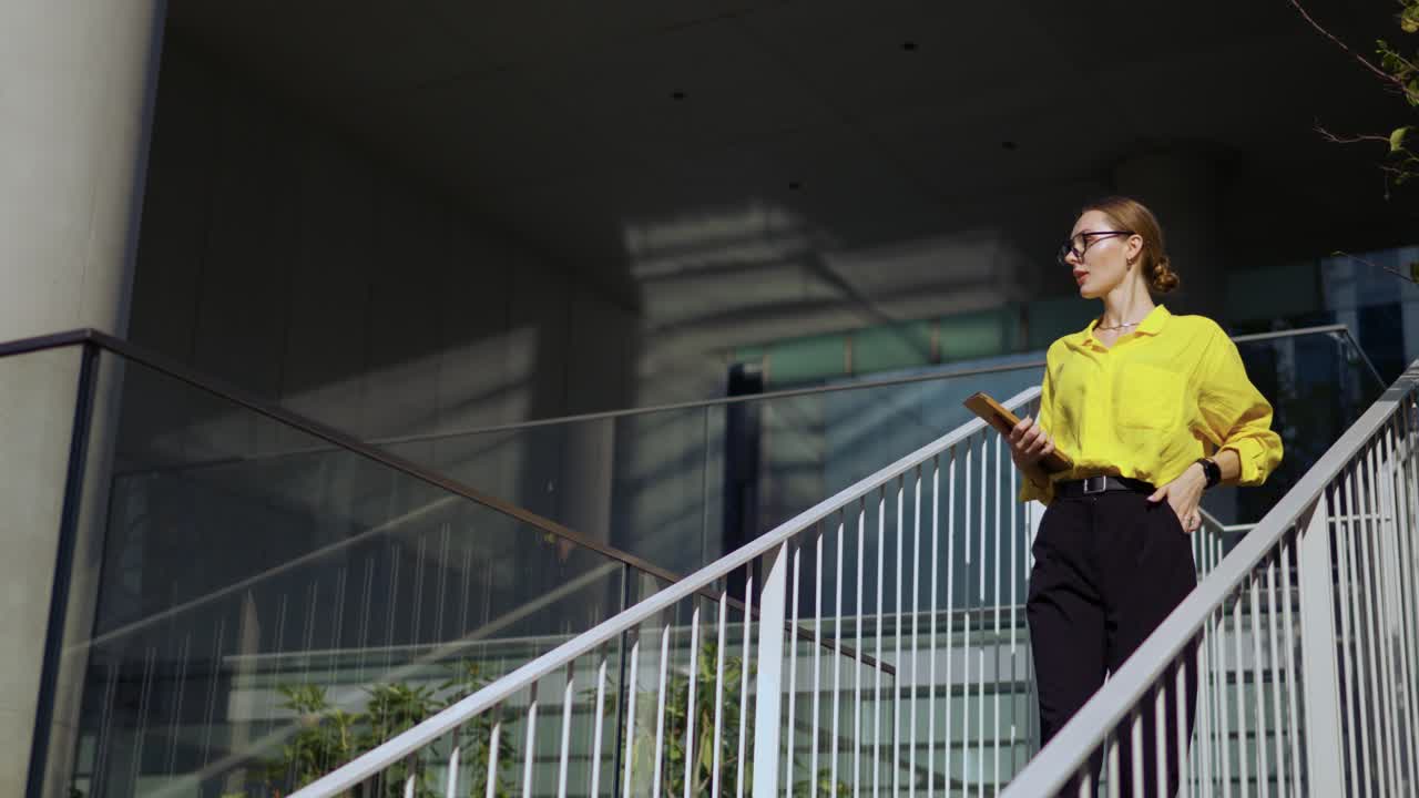 elegante mujer de negocios con camisa amarilla y anteojos