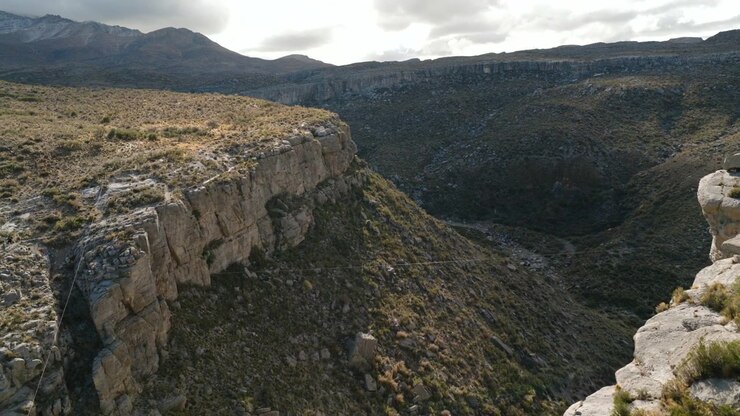 Riprese aeree di una fune d'acciaio per zipline che si estende attraverso un drammatico paesaggio canyon nella provincia di Mendoza