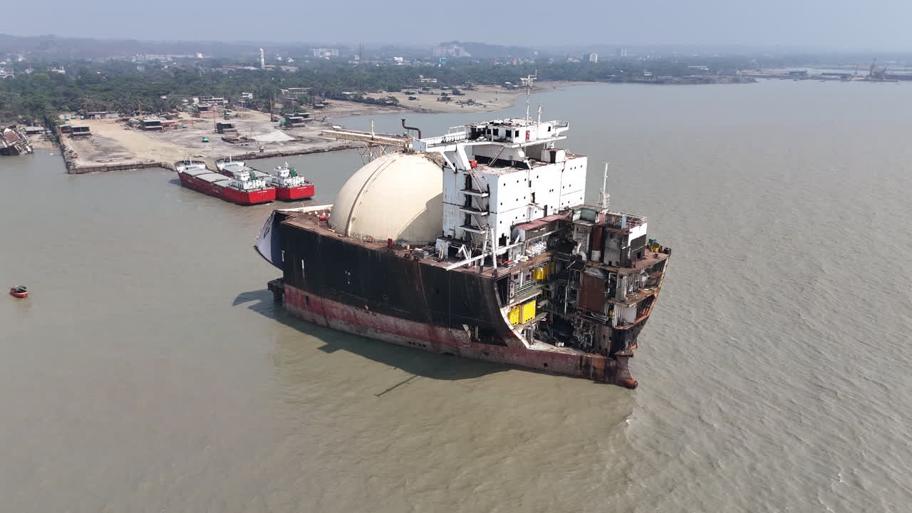 Cinematic panning drone shot of a large ship abandoned in a ship graveyard in Bangladesh.