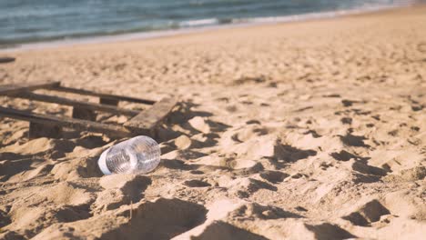 plastic water bottle discarded on a sandy beach