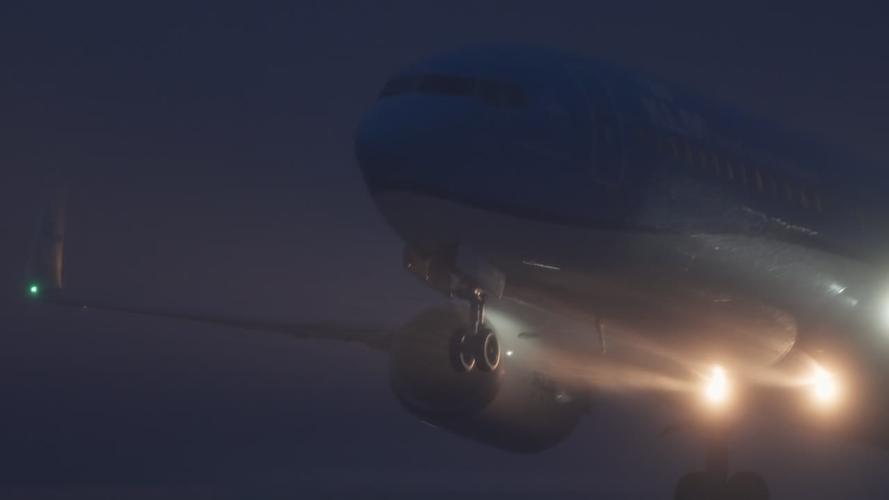 Grande aereo passeggeri in decollo da una pista nebbiosa di notte