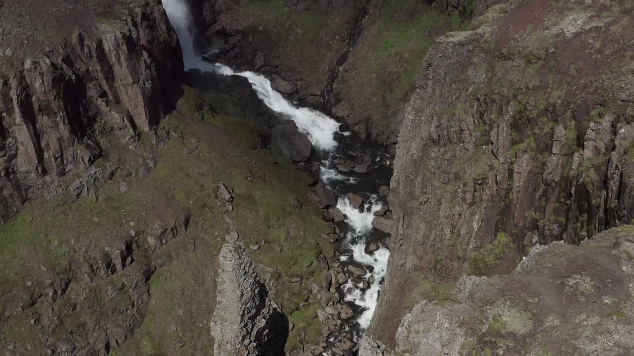 Cinematic reveal shot of deep canyon with whitewater river filled with meltwater