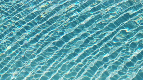 Water-surface-texture,-Slow-motion-clean-swimming-pool-ripples-and-wave,-Refraction-of-sunlight-top-view-texture-sea-side-white-sand,-sun-shine-water-background.-Water-Caustic-Background