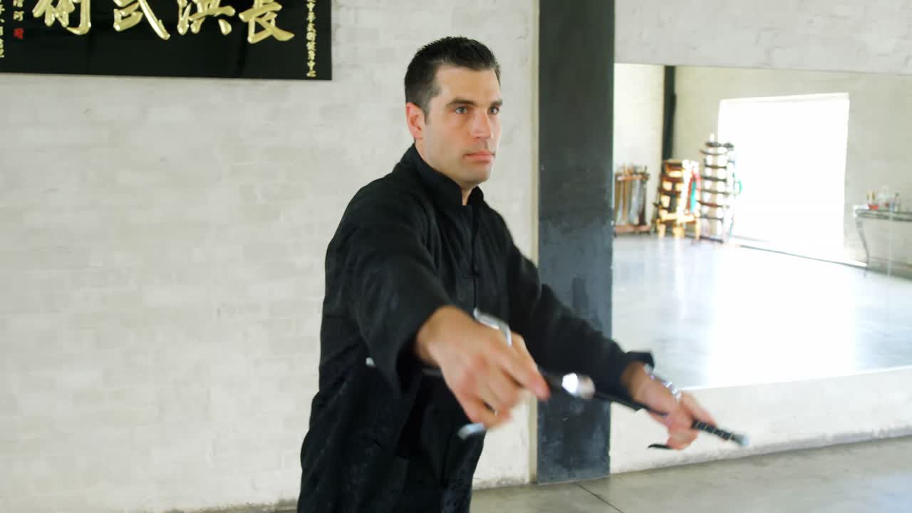 un luchador de kung fu practicando artes marciales con la espada 4k