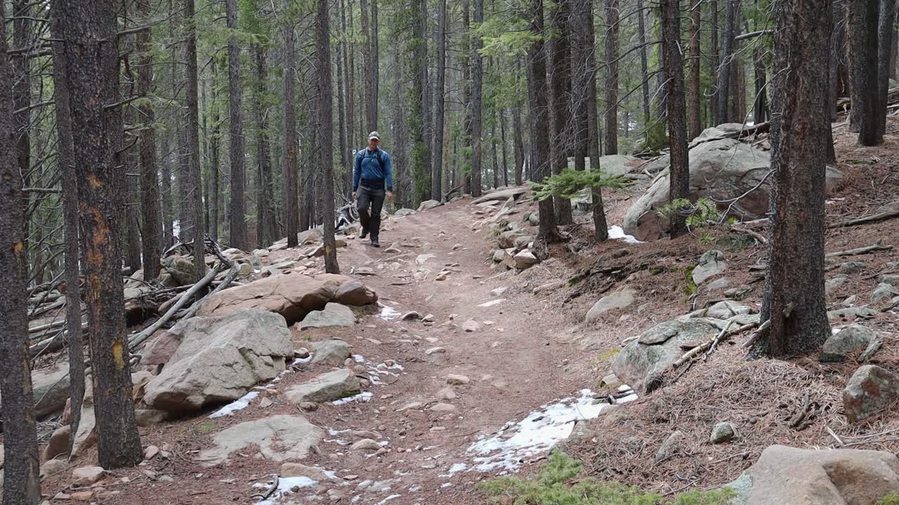 A long male hiker walking down a remote mountain trail. Filmed in Staunton State Park during the spring.