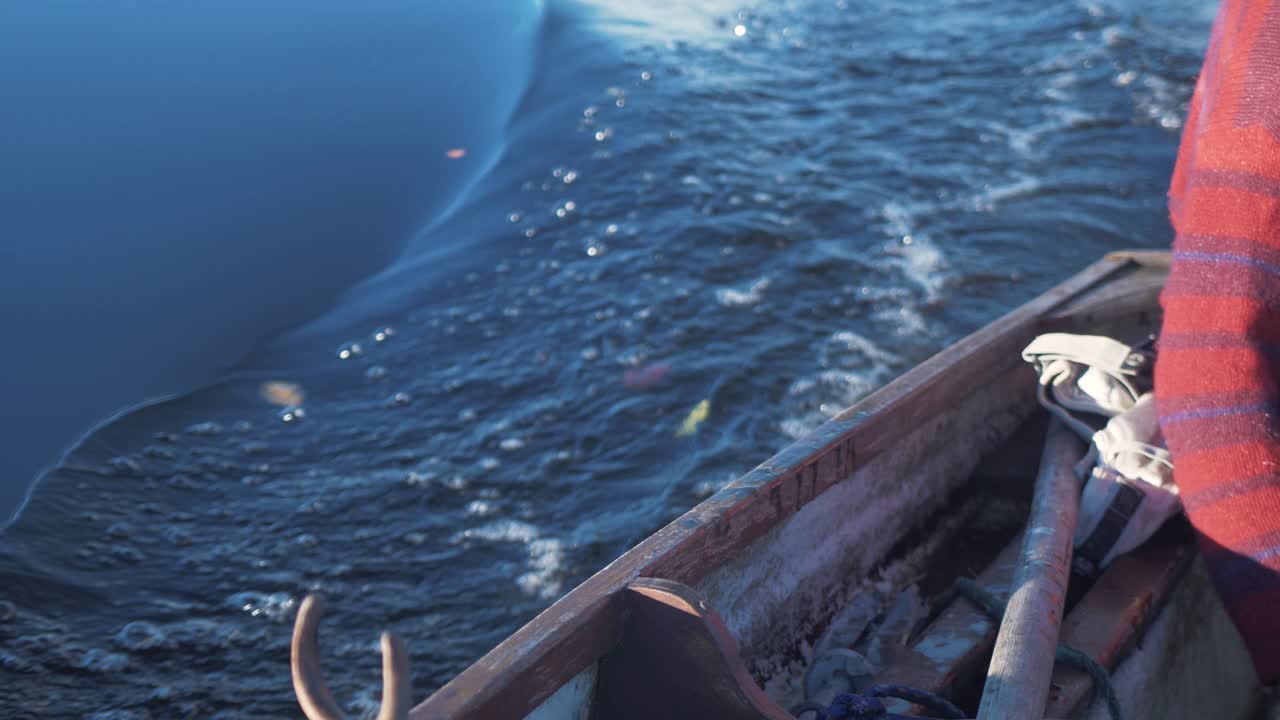 양동이를 사용하여 노 젓는 배의 빌지에서 빗물을 퍼내기