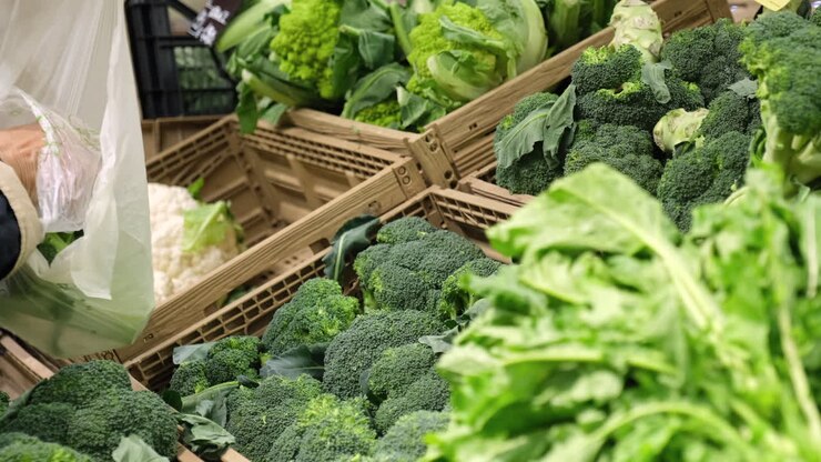 Picking broccoli cauliflower vegetables at super market grocery store