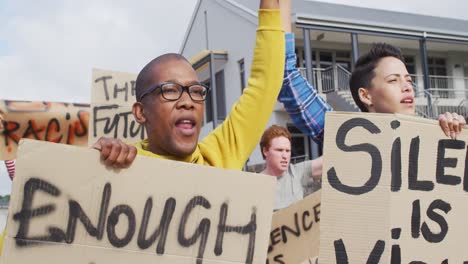 diverse group of protesters holding cardboard banners and screaming