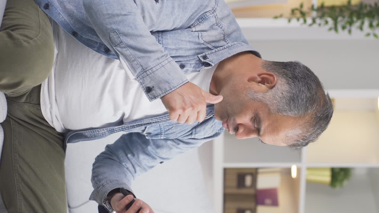 사랑에 빠진 남자가 들어오는 전화 메시지에 흥분하는 수직 비디오입니다.