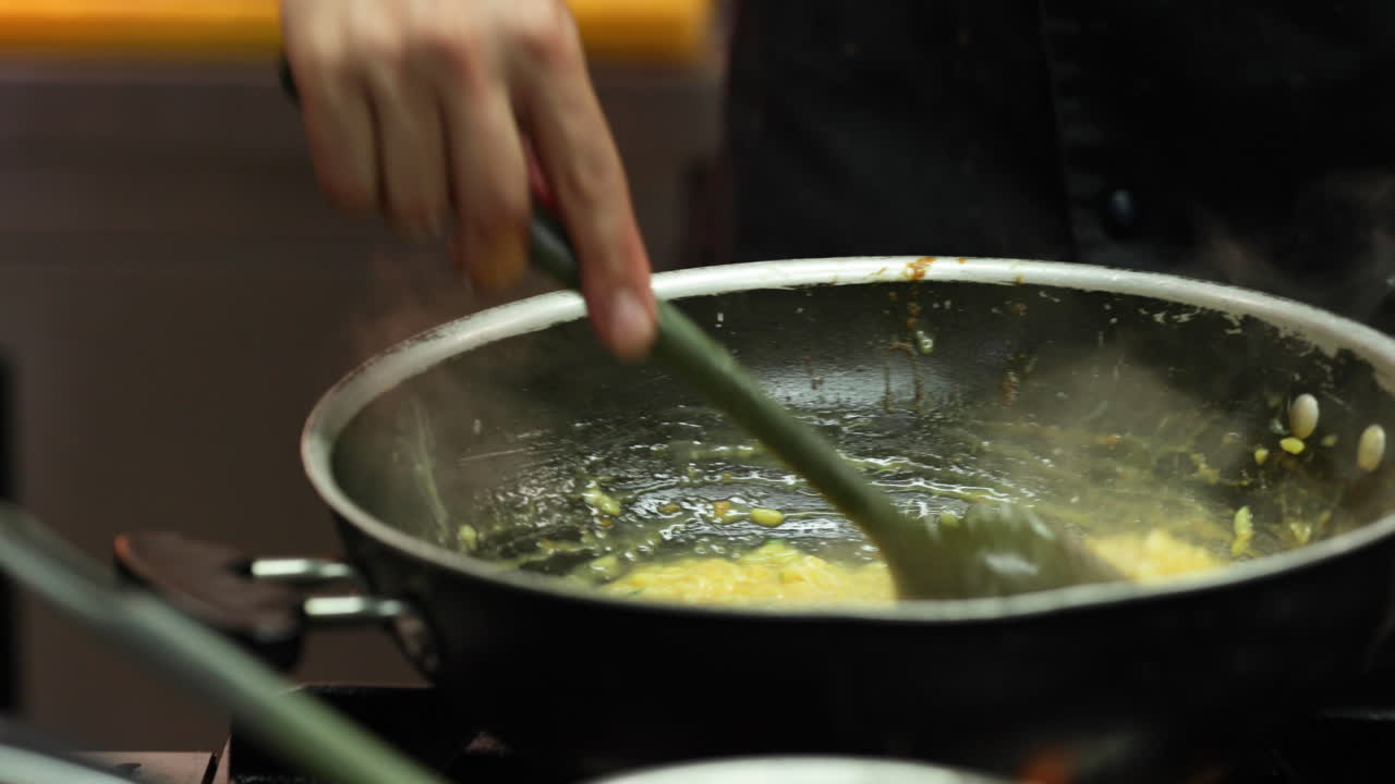 Chef che mescola una salsa cremosa in una padella in cucina