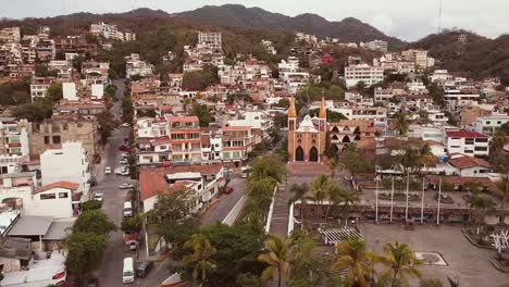 left reveal aerial view drone shot of popular church our lady of guadalupe and public park below as daily life goes on at sunset