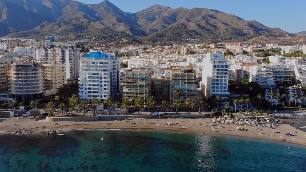 drone disparado paralelamente de lado, filmando la playa en marbella, españa