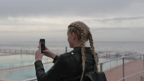 attractive blonde woman taking photos using phone