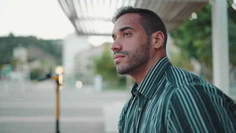 young man resting while sitting in bench outdoors.