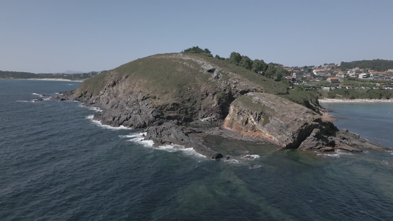 Filmato grezzo di una scogliera mozzafiato con onde e oceano scuro in un villaggio costiero