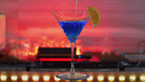 Leerer-Glasbecher-Cocktail-Auf-Rotem-Hintergrund,-Nachtclub,-Gefüllt-Mit-Blauem-Getränk-Von-Einem-Professionellen-Barkeeper