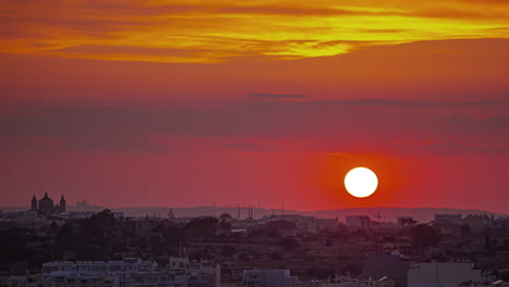 beautiful red yellow sunset sky, orange ball of sun sets on marsaxlokk, malta, timelapse