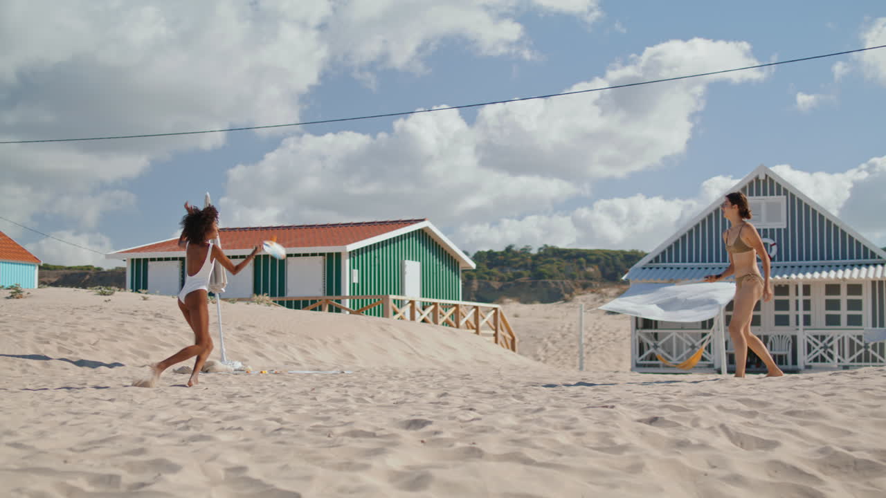 amigas jugando a la playa en un día soleado. una pareja lgbt alegre disfrutando del tenis.