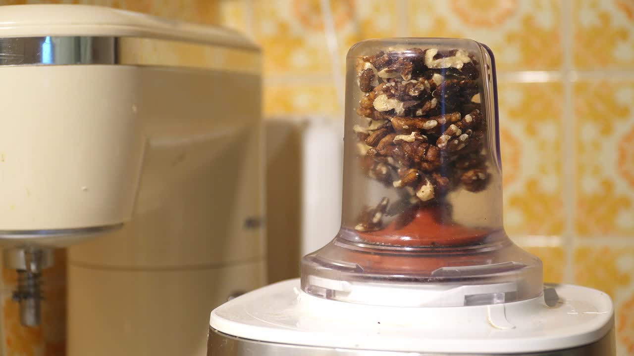Grinding nuts on an electric grinder. Closeup.