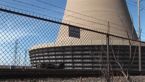 the camera pans from the base of a nuclear power plant to the top of its curved structure