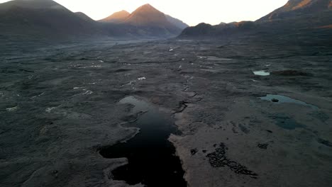 Flying-over-Scottish-moorland-loch-towards-mountains-at-dawn-at-Sligachan-on-the-Isle-of-Skye-Scotland