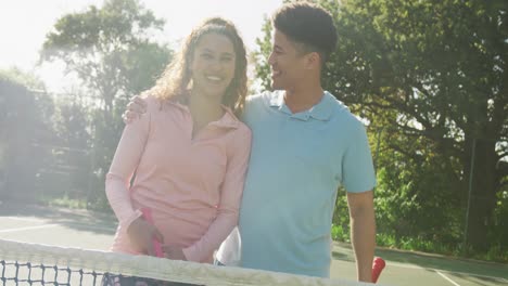 video of happy biracial couple playing tennis on the court