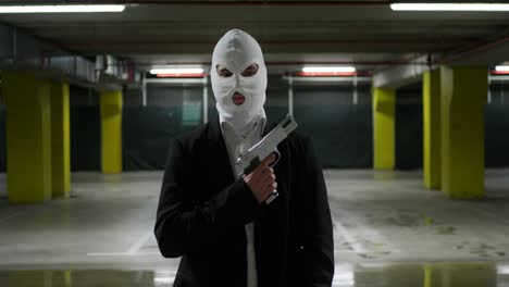 man in a suit with a white mask holding a fun criminal