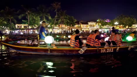 boatmen and boat ladies take tourists and visitors on an evening tour of thu bon river at a section of the old quarter in the city of hoi an, vietnam.