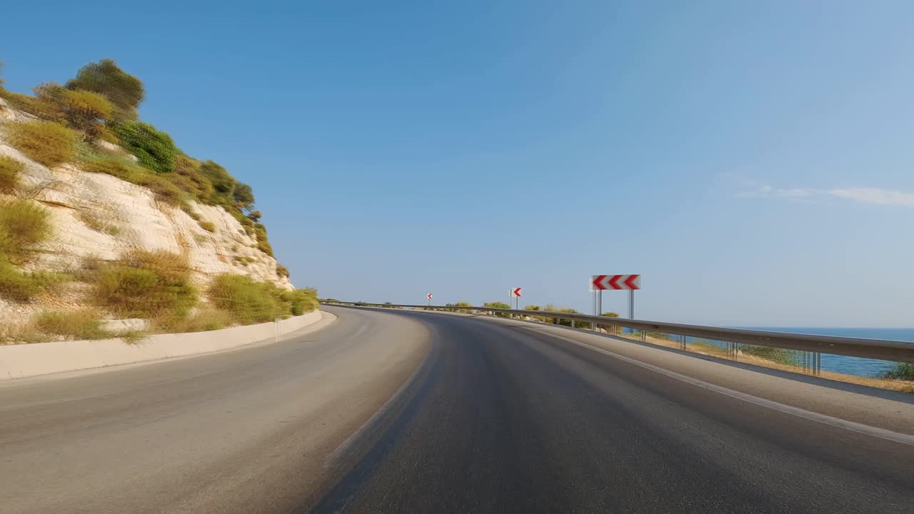 바다 와 바위 가득 찬 산 기?? 사이 의 휘어지는 도로 의 곡선 에서 빠르게 운전 하는 것