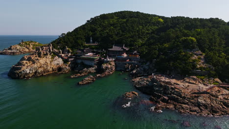 drone rising in front of the haedong yonggungsa temple, sunny busan, south korea