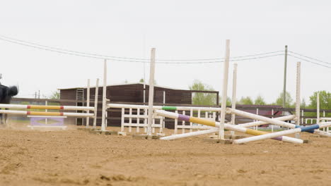 jinete montando un caballo negro que salta obstáculos