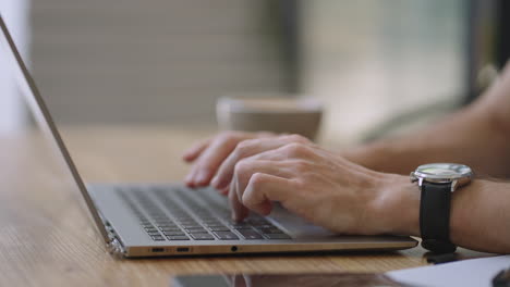 male hands of business man professional user worker using typing on laptop notebook keyboard sit at home office desk working online with pc software apps technology concept close up side view