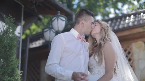 wedding. beautiful lovers embrace. bride and groom smile to each other standing before green trees