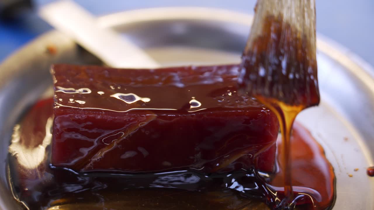 요리사가 레스토랑에서 아시아 국수를 위해 참치 조각을 준비하고 있습니다.