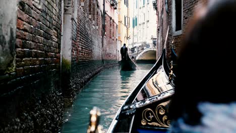 back view of senior woman enjoying beautiful gondola excursion tour on narrow venice canal during retirement vacation.