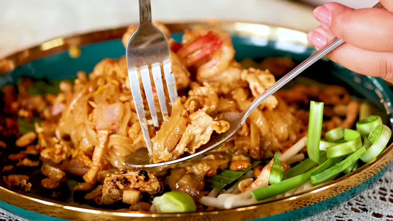 Fork and spoon serving delicious Pad Thai