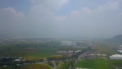 Vista-Aérea-De-Los-Campos-Agrícolas-Cerca-De-La-Ciudad-De-México-Y-Alrededor-De-Los-Volcanes