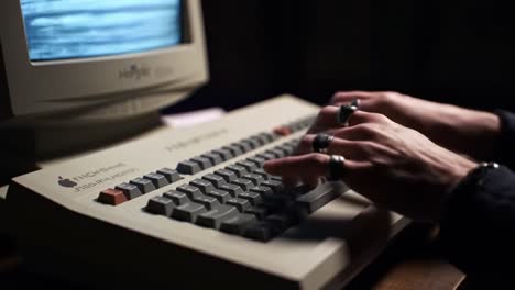 a glimpse into retro computing: engaging with a vintage keyboard and monitor setup, capturing the nostalgic essence of early digital interaction