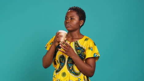 Young-smiling-person-enjoying-freshness-of-coffee-cup-in-studio