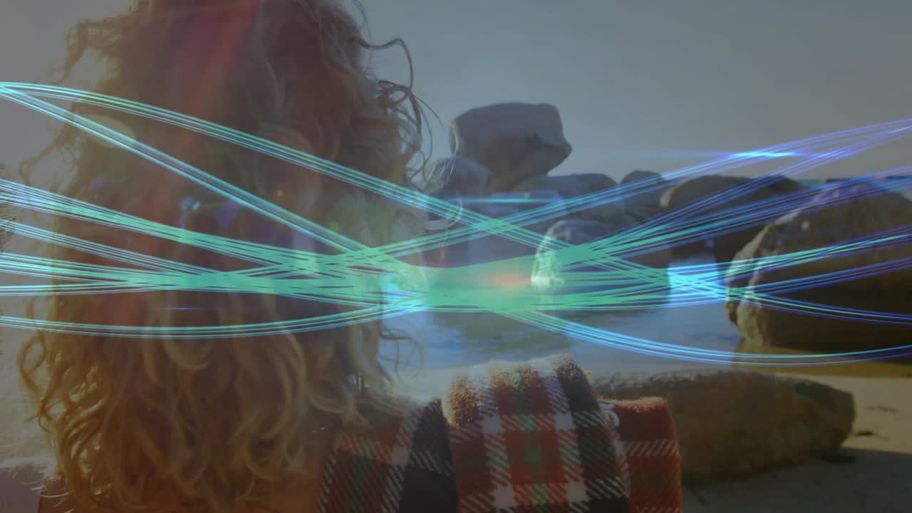 Woman adjusting hair and turning while admiring sunlit sea with animated teal-blue streaks for tech