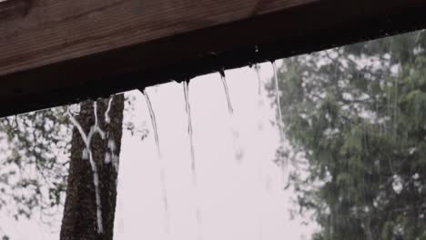 rain water streaming out of overflowing gutter during intense thunderstorm